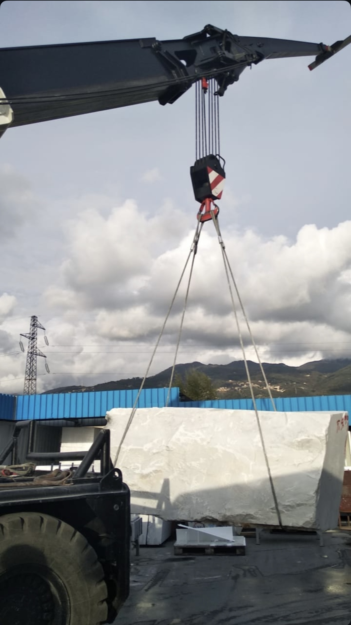 A marble block lifted by crane in Pietrasanta