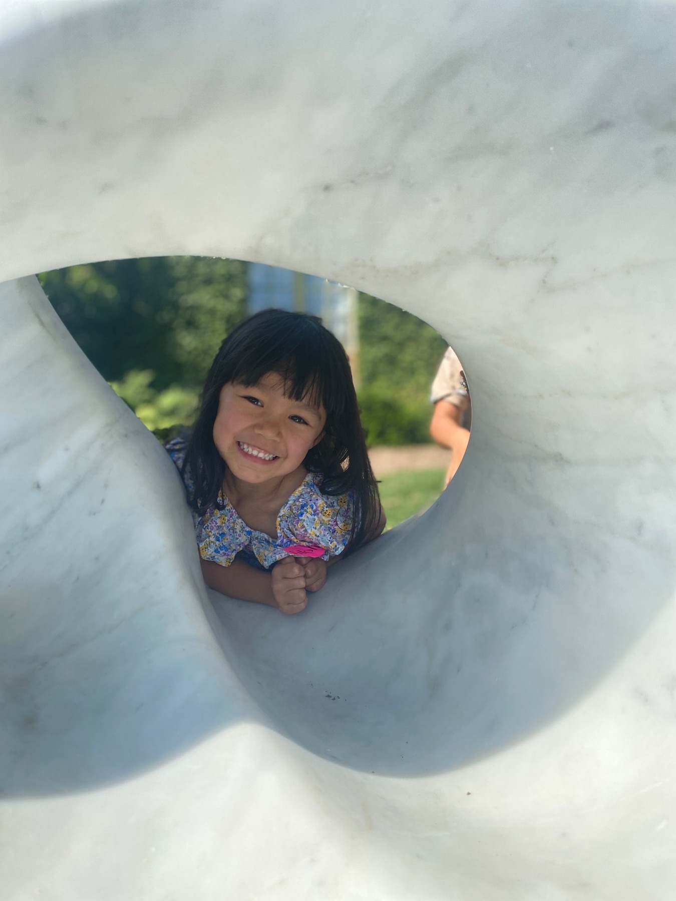 Young visitor looking through an opening in a Yoko Kubrick marble sculpture during Ovid's Metamorphosis at Filoli