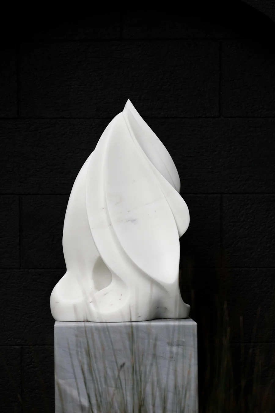 The Capture of Persephone marble sculpture against a dark wall