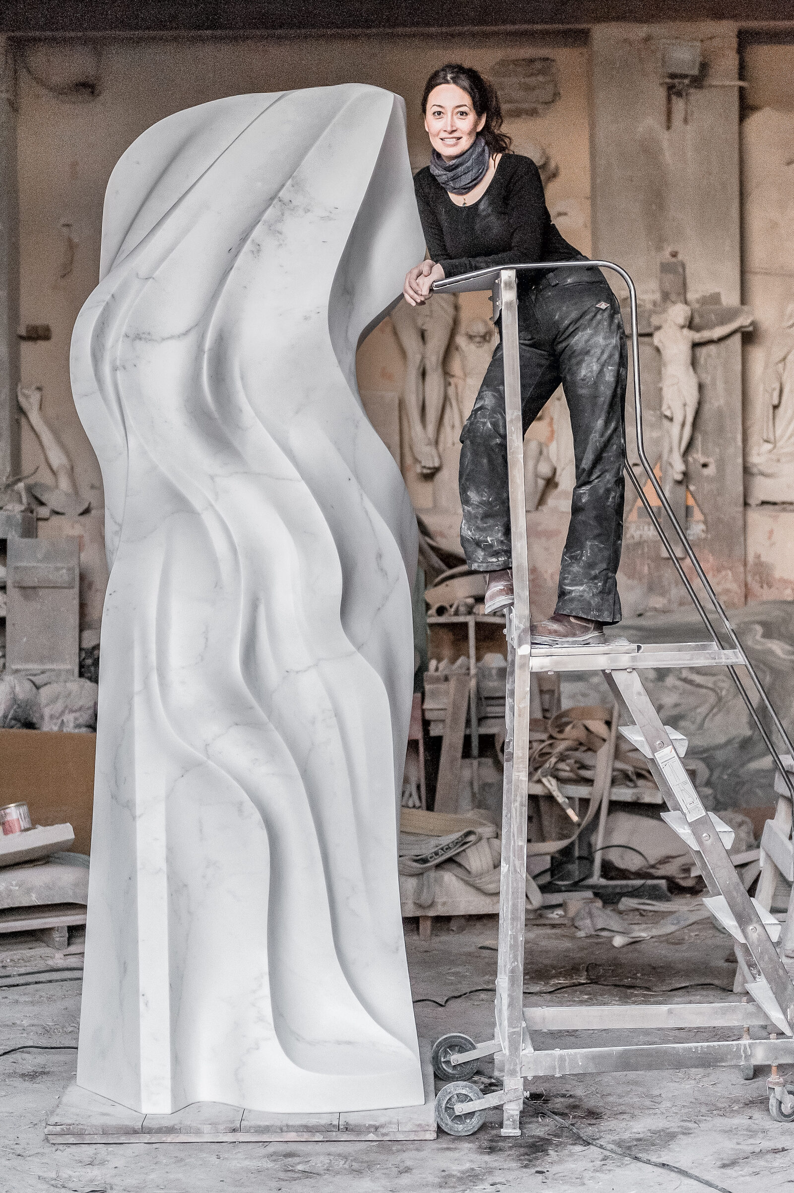 Lethe substantially completed in the Pietrasanta workshop, with Yoko Kubrick on a ladder beside the sculpture
