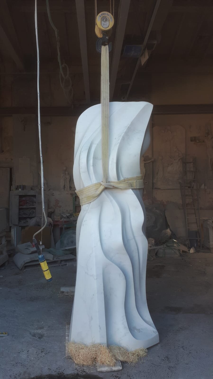 A finished marble sculpture rigged for transport in the workshop
